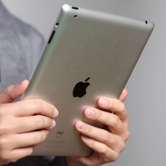 Hands holding a silver iPAD.