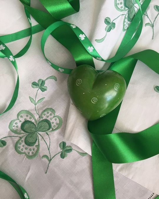 Irish linen tablecloth hand-embroidered with
                      shamrocks together with green ribbon, shamrock
                      printed ribbon, and a green stone heart