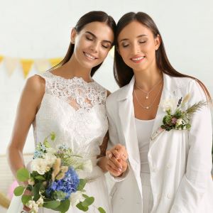 Two
brides with eyes closed holding hands