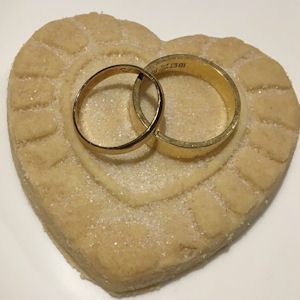 Two gold wedding rings on a heart-shaped
shortbread biscuit