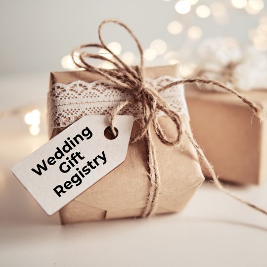 Gifts wrapped in
kraft paper and lace and tied with string. One
has a luggage tag attached that reads
"Wedding Gift Registry" in black ink.