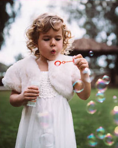 Flower girl blowing bubbles through a red
wand