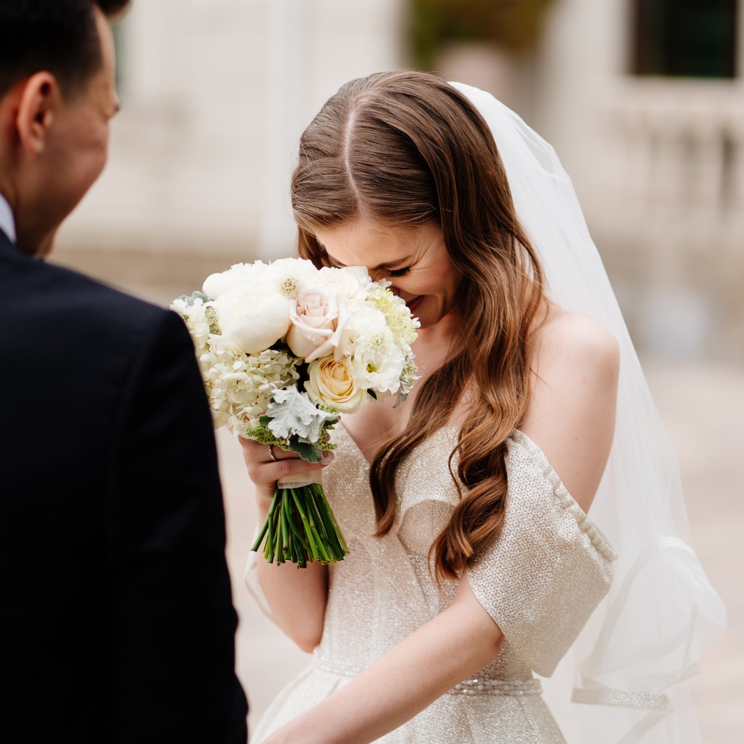 Bride laughing during the vows,
hiding her face behind her bouquet
