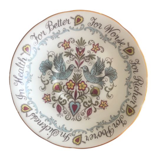 Bone China saucer that has the words
For Better For Worse In Sickness In Health
round the rim and an illustration of two
blue birds in the centre together with
stylised floral elements